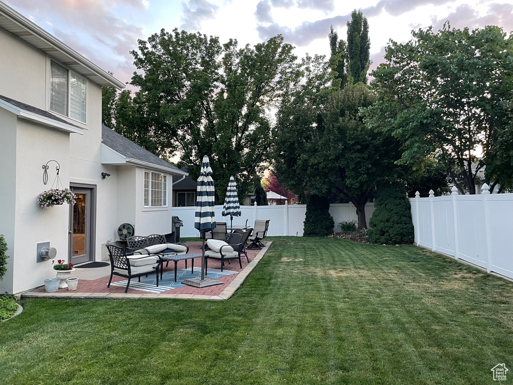 Fenced backyard featuring an outdoor hangout area and a patio
