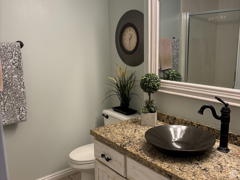 Bathroom featuring tile patterned flooring, vanity, and a stall shower