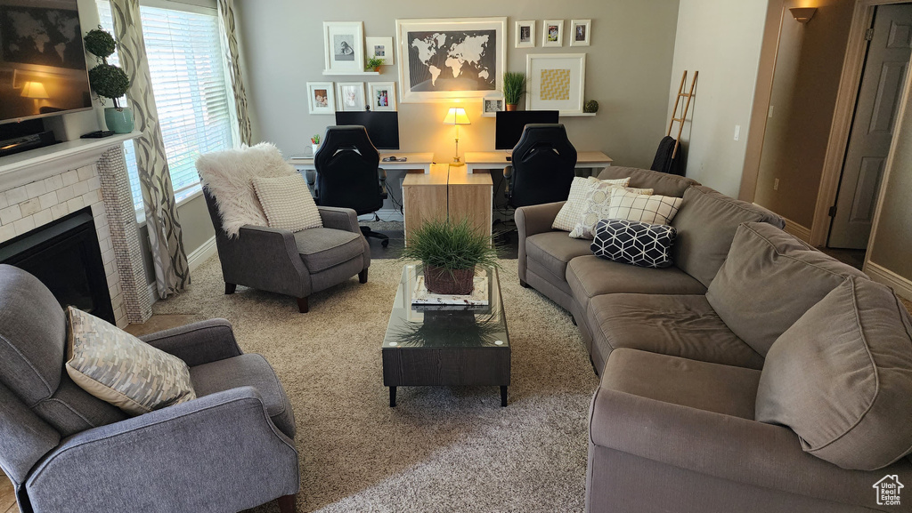 Carpeted living room with an office area and a fireplace