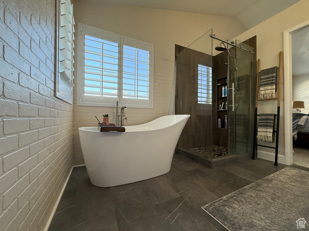 Bathroom featuring a shower stall, a freestanding tub, and connected bathroom