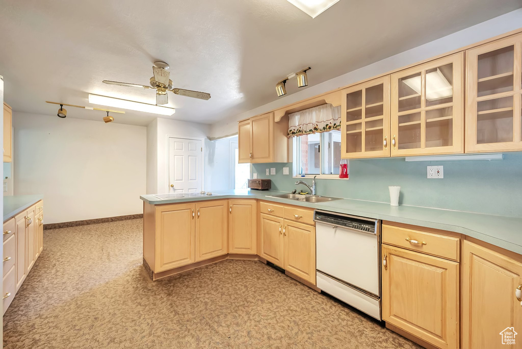 Kitchen with white dishwasher, a peninsula, light brown cabinetry, and a ceiling fan