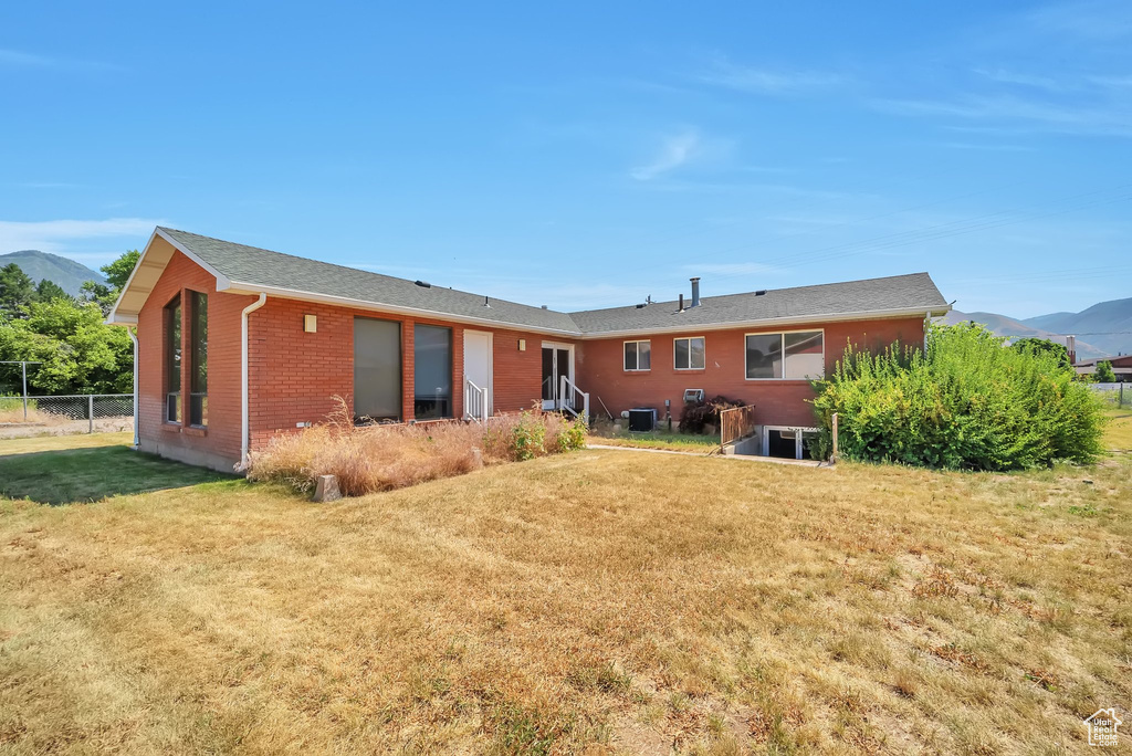 Rear view of house featuring a mountain view, brick siding, and a shingled roof