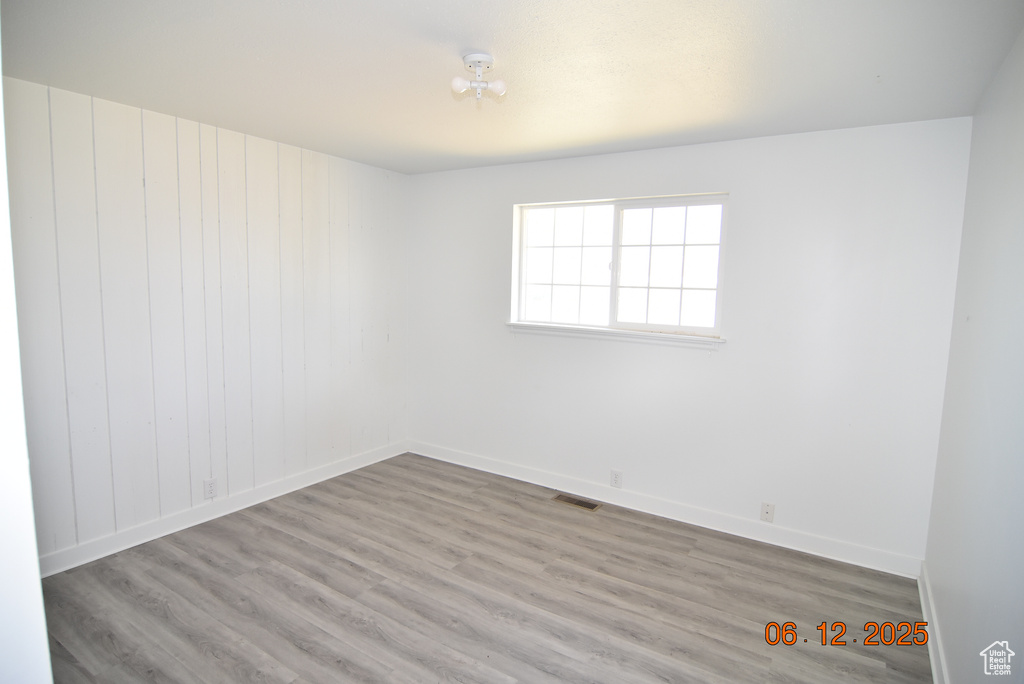 Unfurnished room with wood finished floors and baseboards