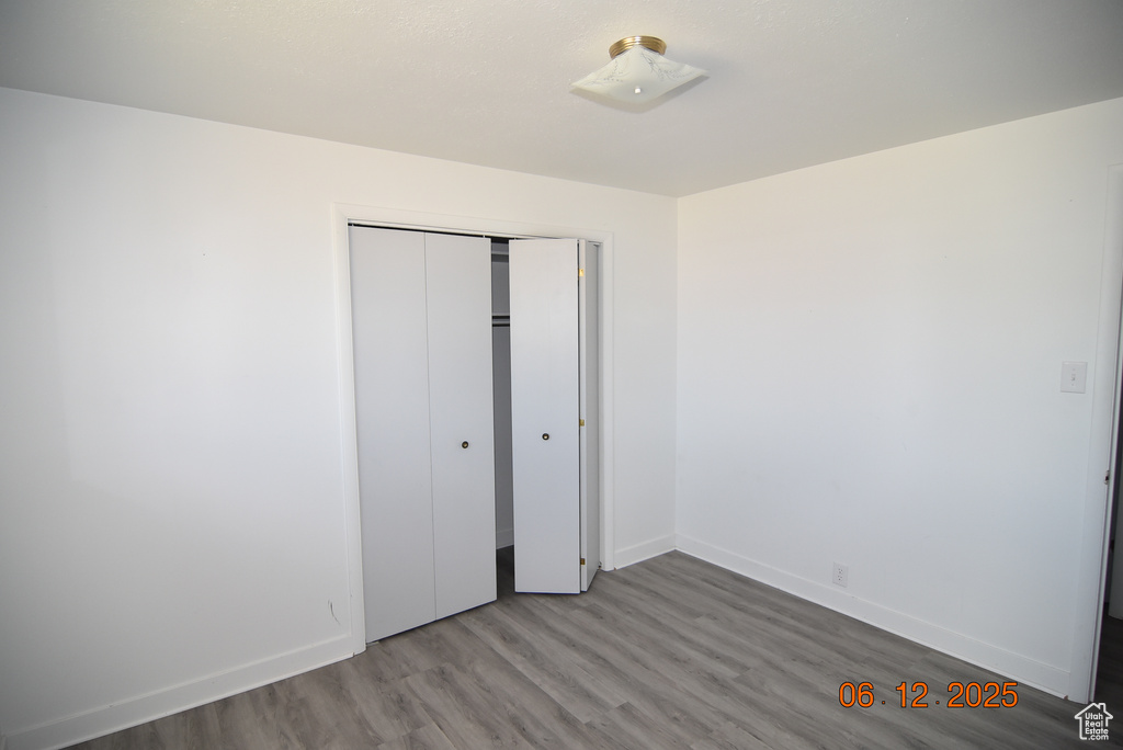 Unfurnished bedroom featuring wood finished floors and a closet