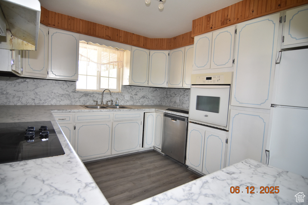 Kitchen featuring white appliances, extractor fan, backsplash, light countertops, and white cabinets
