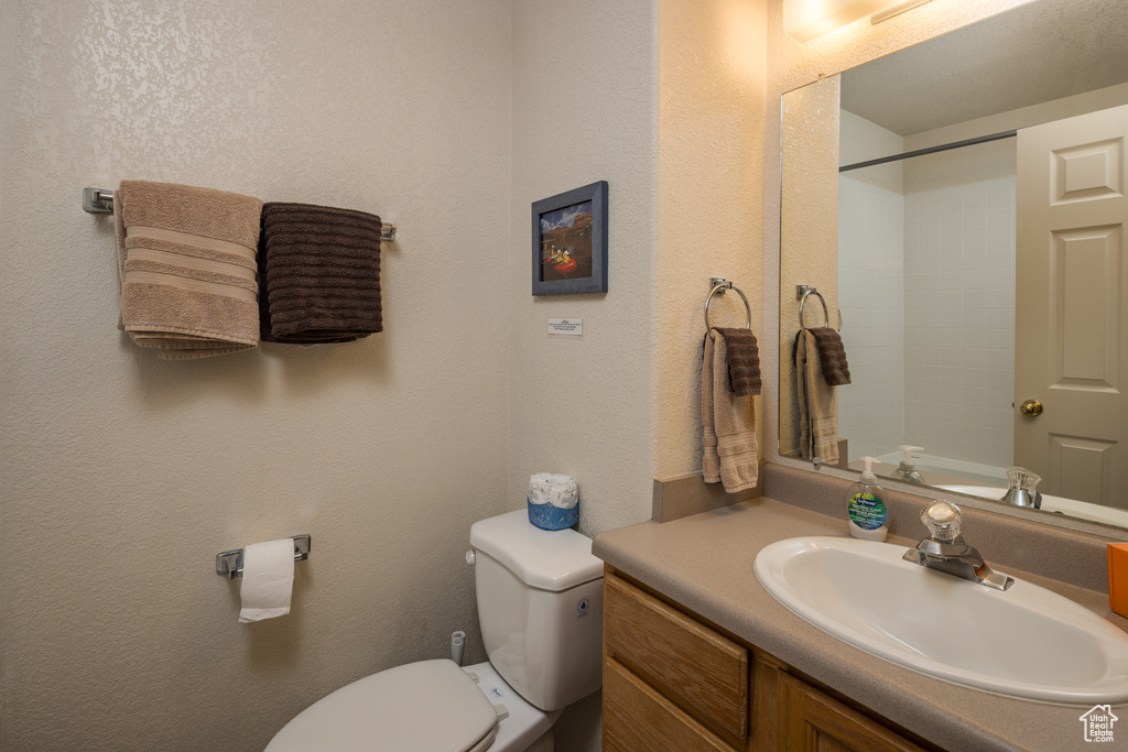 Bathroom featuring vanity, a shower, and a textured wall
