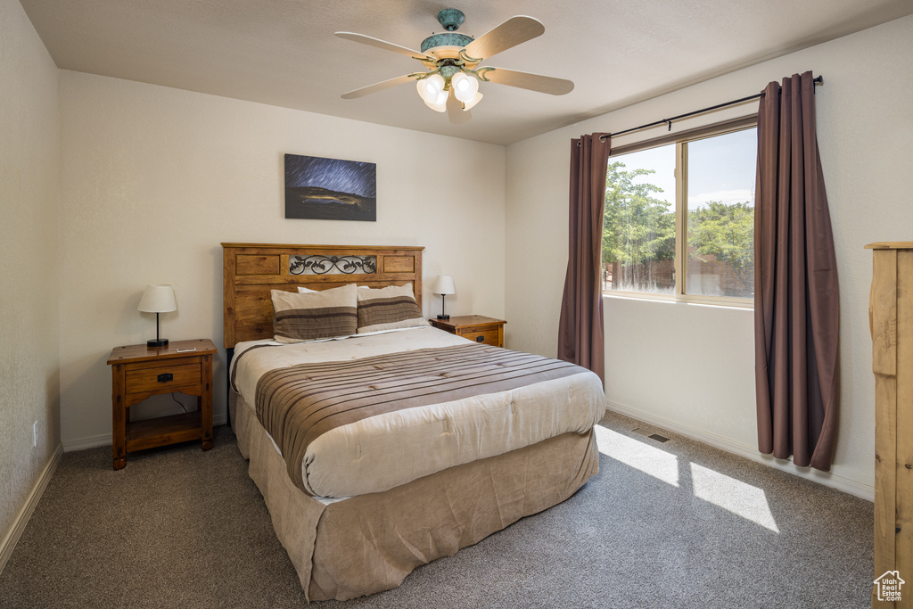 Carpeted bedroom with baseboards and ceiling fan
