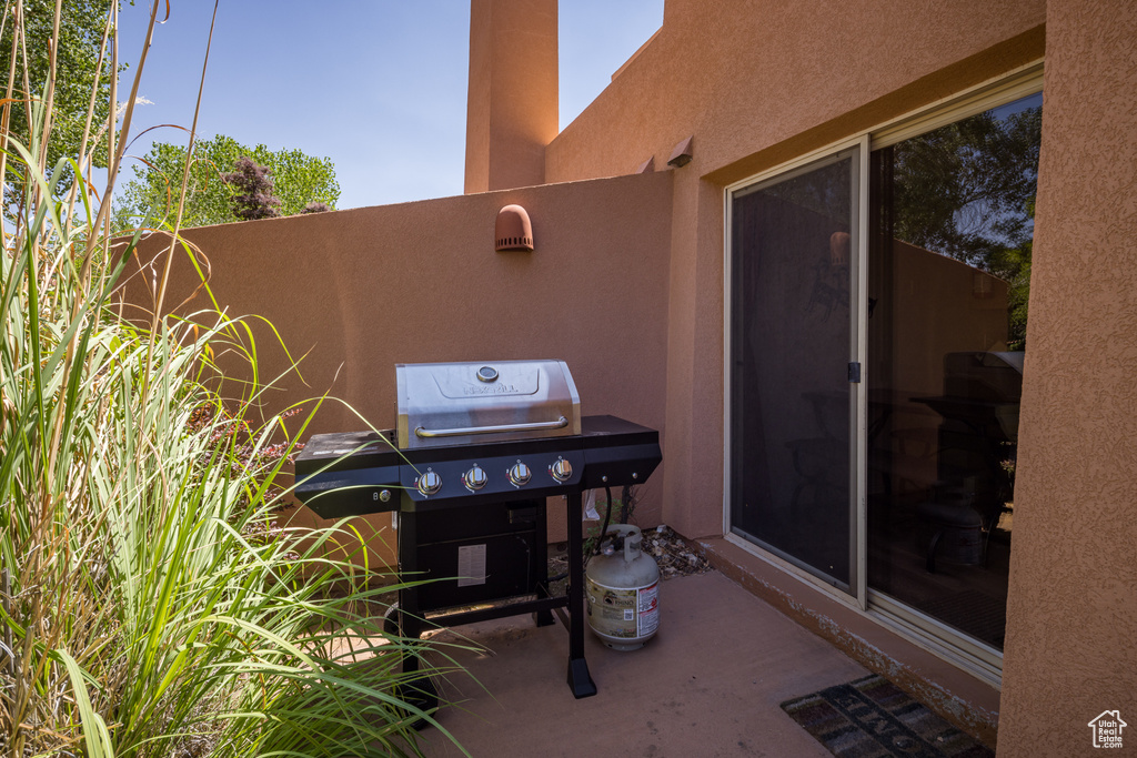 View of patio with a grill