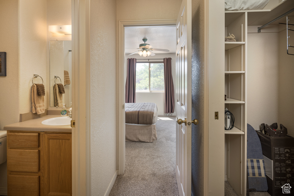 Bathroom with vanity, ceiling fan, and a textured wall