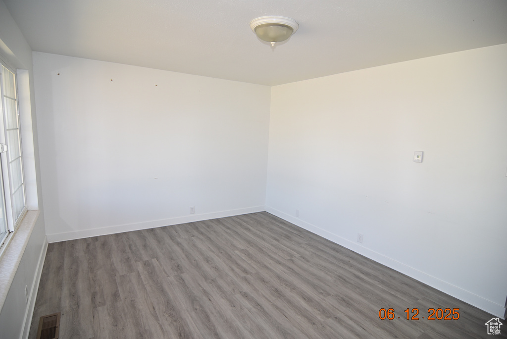 Spare room featuring wood finished floors and baseboards