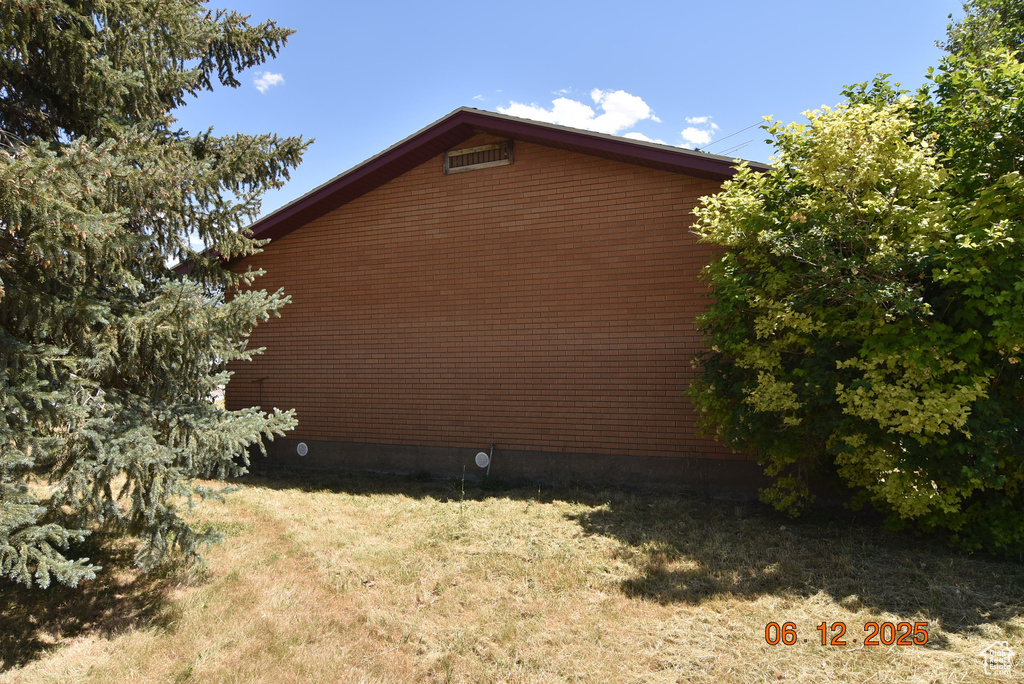 View of side of home featuring a yard