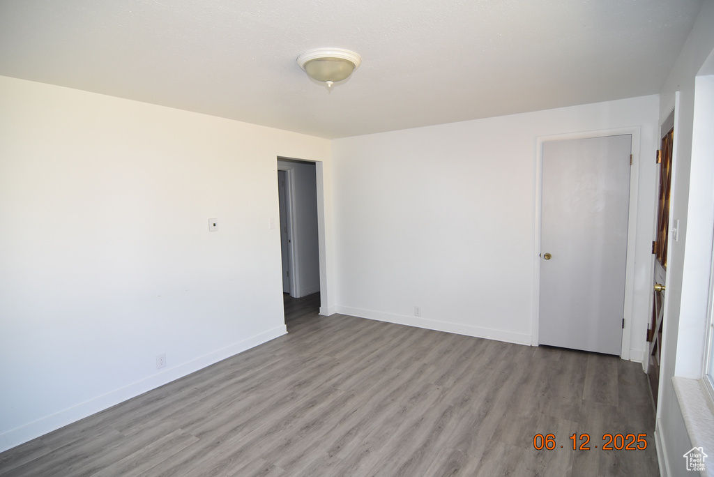 Unfurnished room with wood finished floors and baseboards
