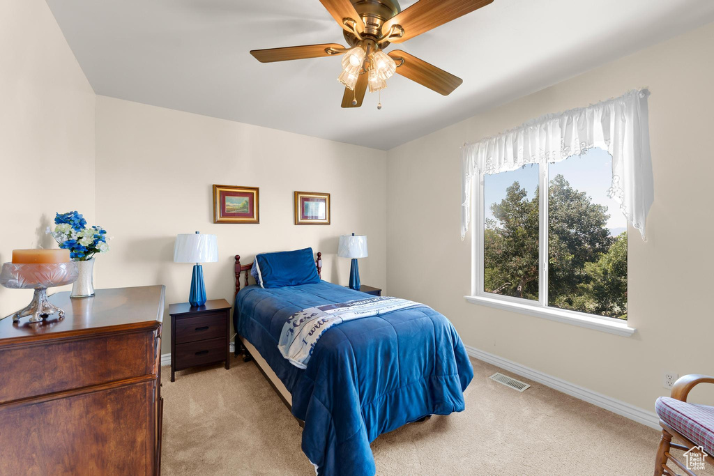 Carpeted bedroom featuring baseboards and a ceiling fan