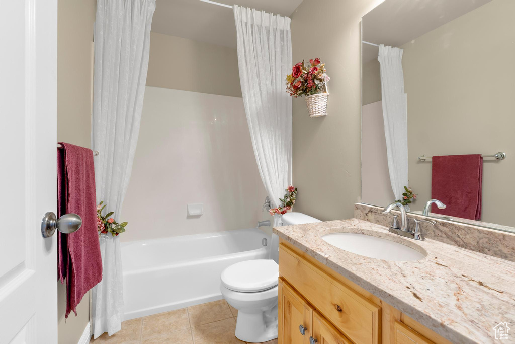 Bathroom featuring vanity, tile patterned floors, and shower / bath combo with shower curtain