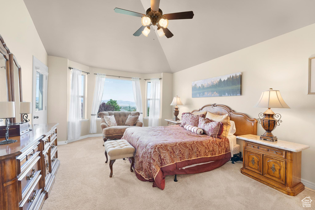 Bedroom with light colored carpet, lofted ceiling, and a ceiling fan