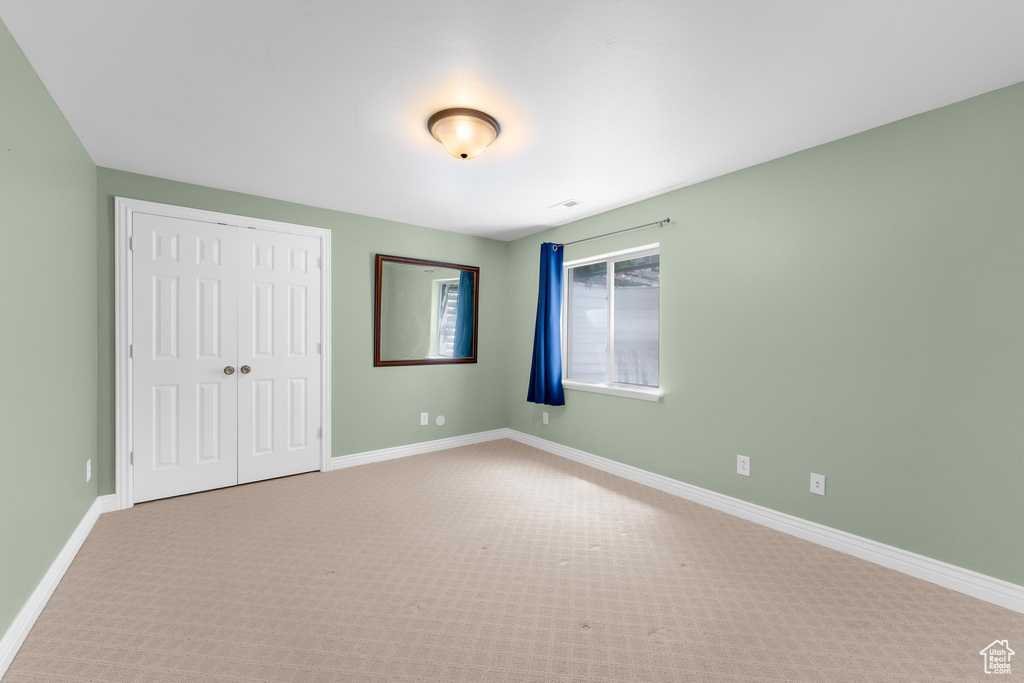 Unfurnished bedroom featuring a closet and carpet flooring