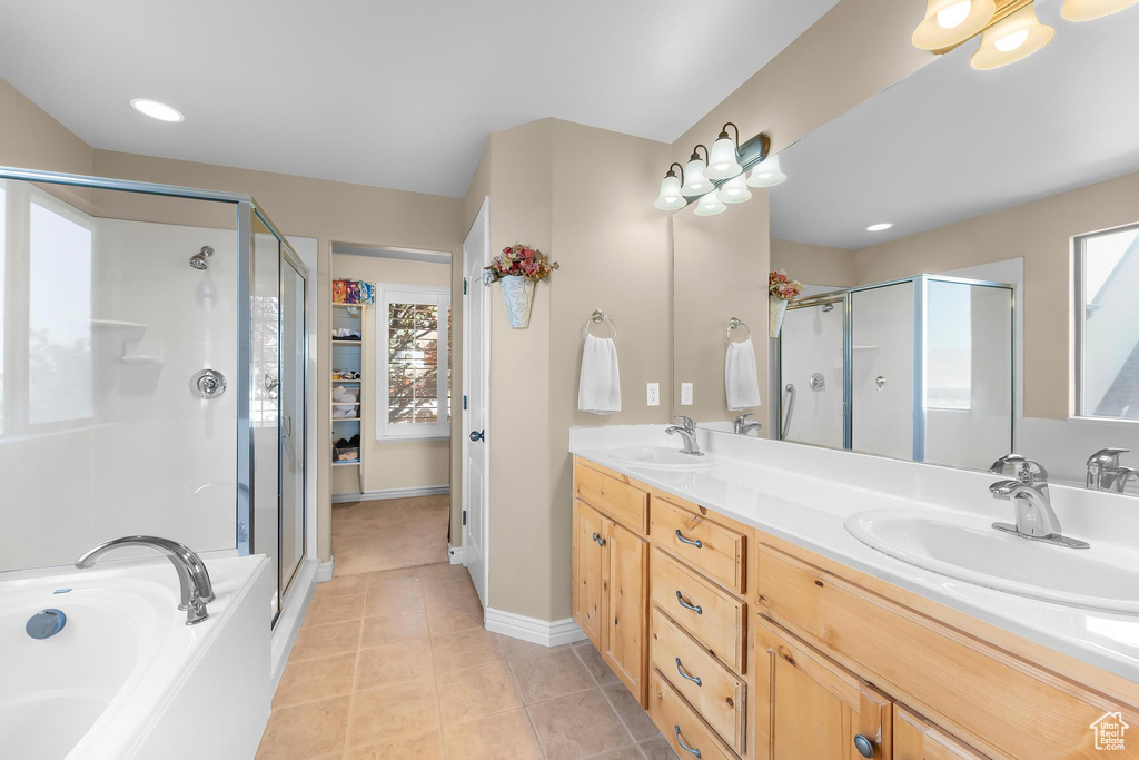 Bathroom featuring a shower stall, double vanity, a garden tub, and tile patterned flooring