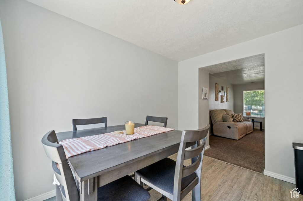 Dining space featuring light wood finished floors and a textured ceiling