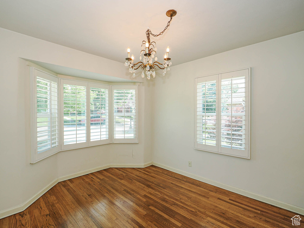 Spare room with a chandelier and hardwood / wood-style flooring