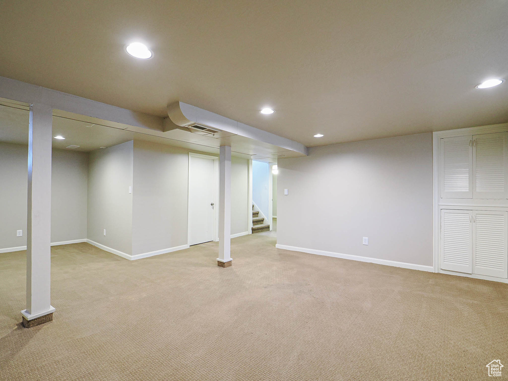 Finished below grade area featuring recessed lighting, carpet, and stairs