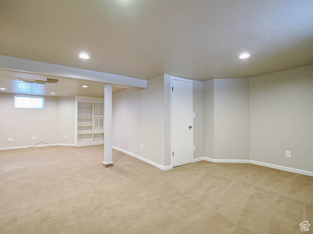 Basement with light colored carpet and recessed lighting
