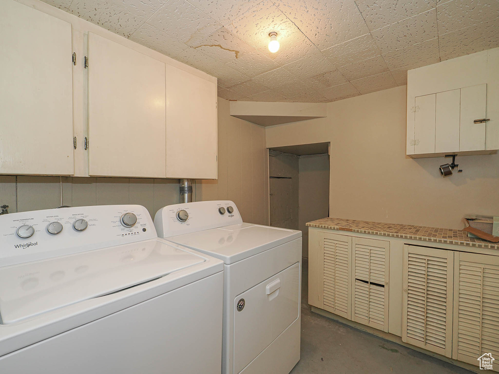 Washroom featuring cabinet space and separate washer and dryer