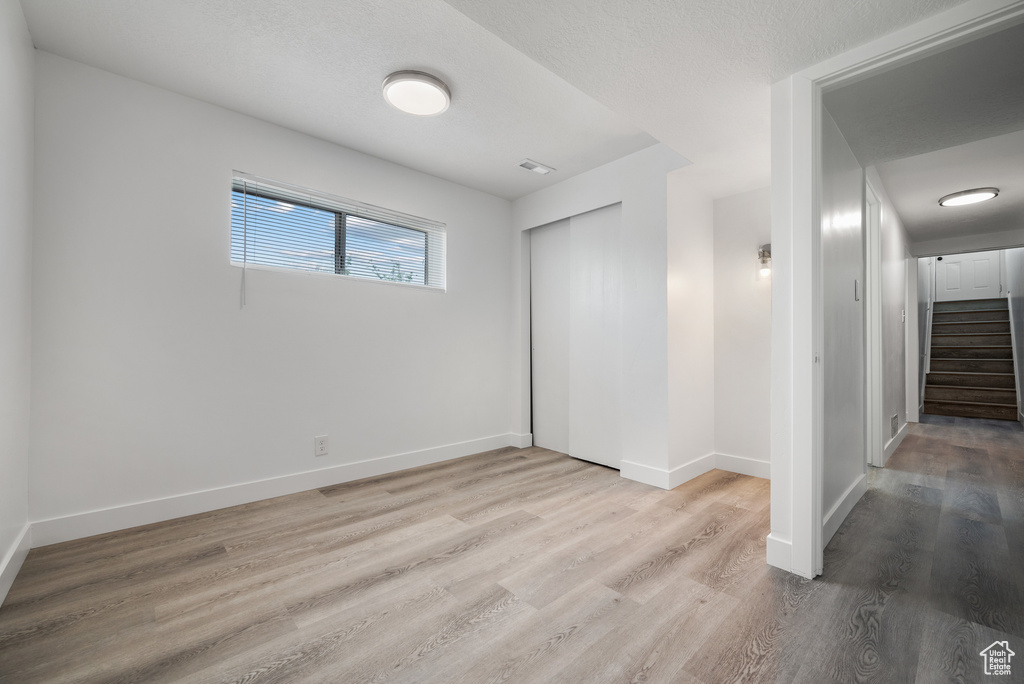 Unfurnished bedroom with wood finished floors and a closet