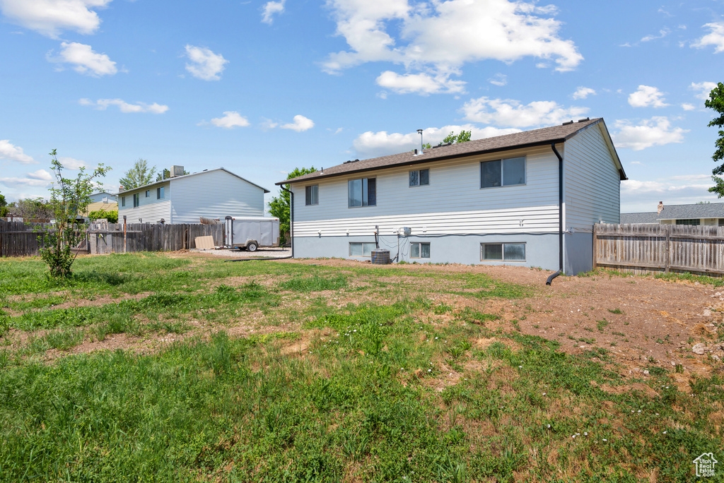 Back of house with a fenced backyard