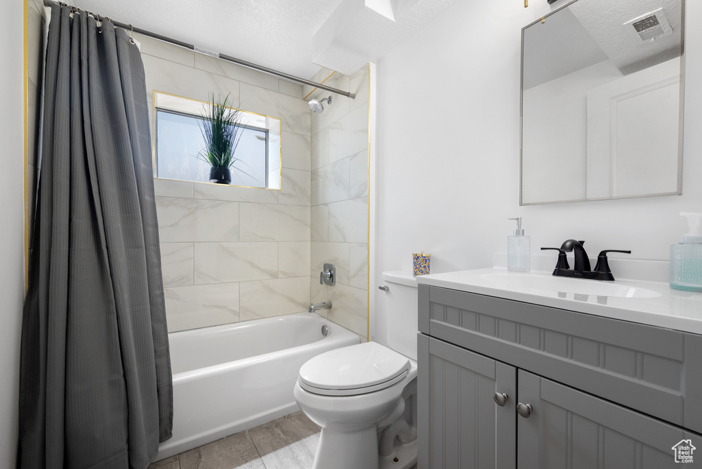 Bathroom featuring shower / bathtub combination with curtain and vanity