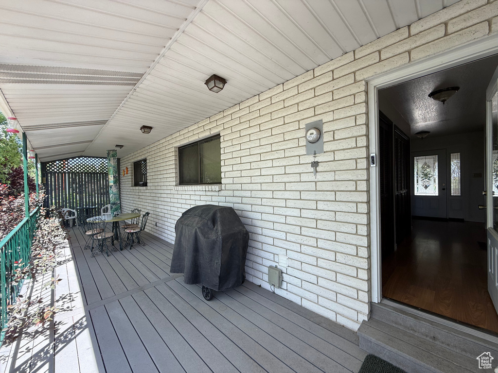 Wooden deck with outdoor dining space and area for grilling