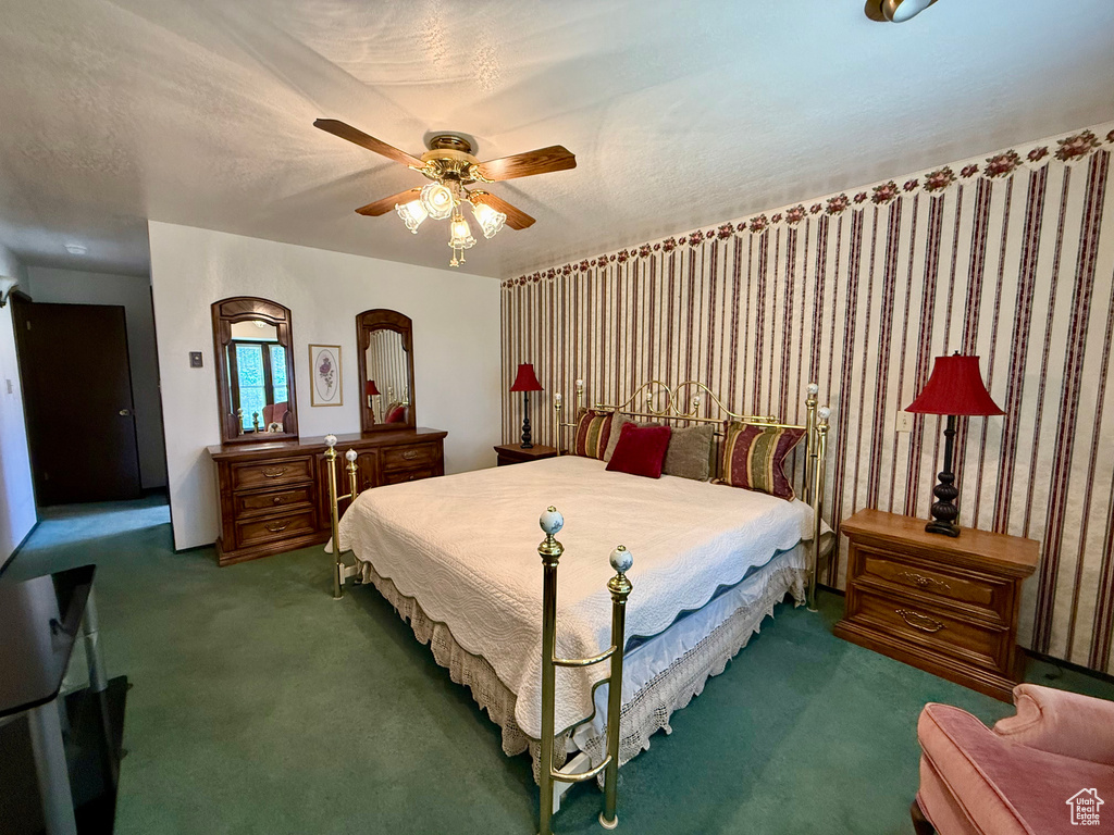 Carpeted bedroom featuring ceiling fan