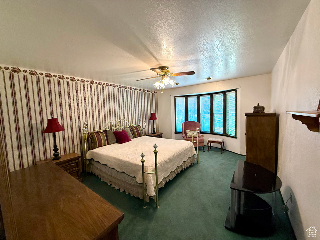 Carpeted bedroom with a textured ceiling and a ceiling fan