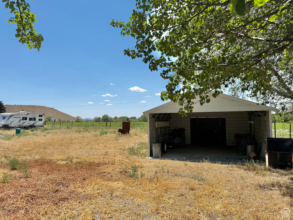 View of yard with a garage and an outbuilding
