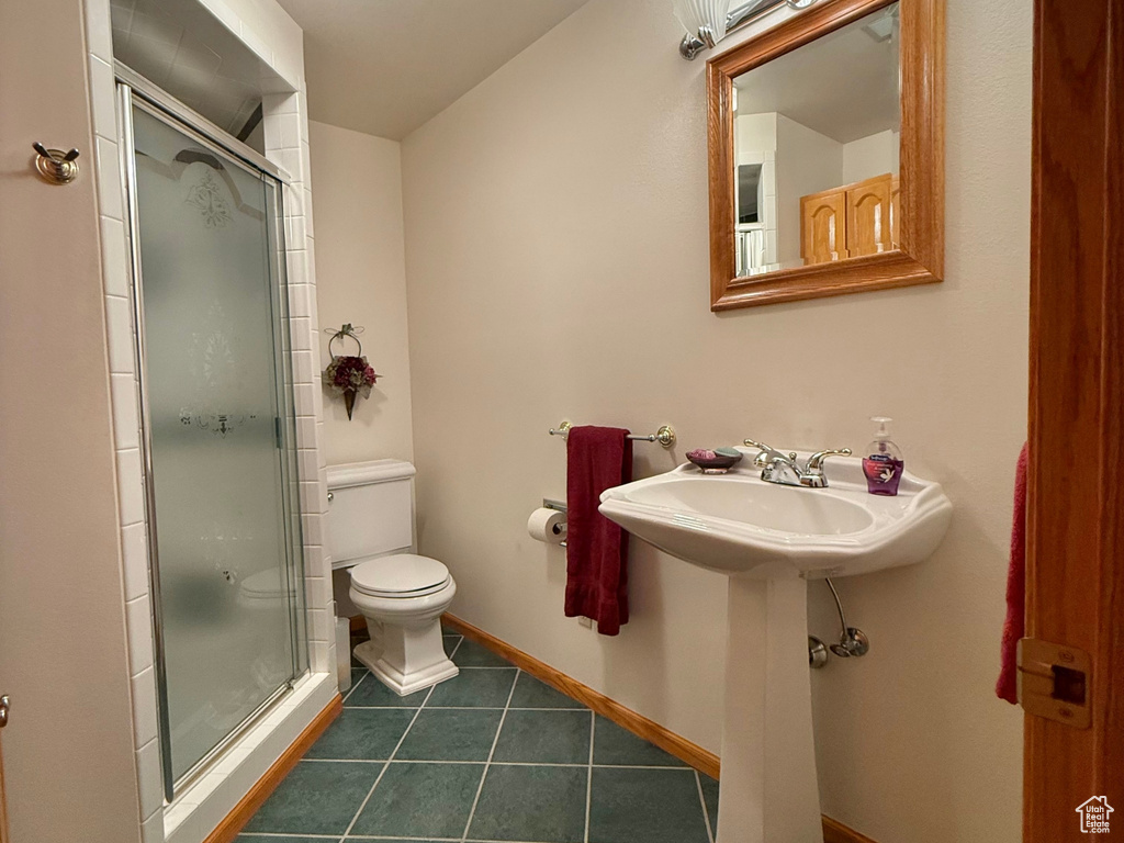 Bathroom with a shower stall and tile patterned flooring