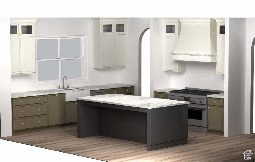 Kitchen with custom exhaust hood, stainless steel range, light wood-style flooring, a kitchen island, and glass insert cabinets