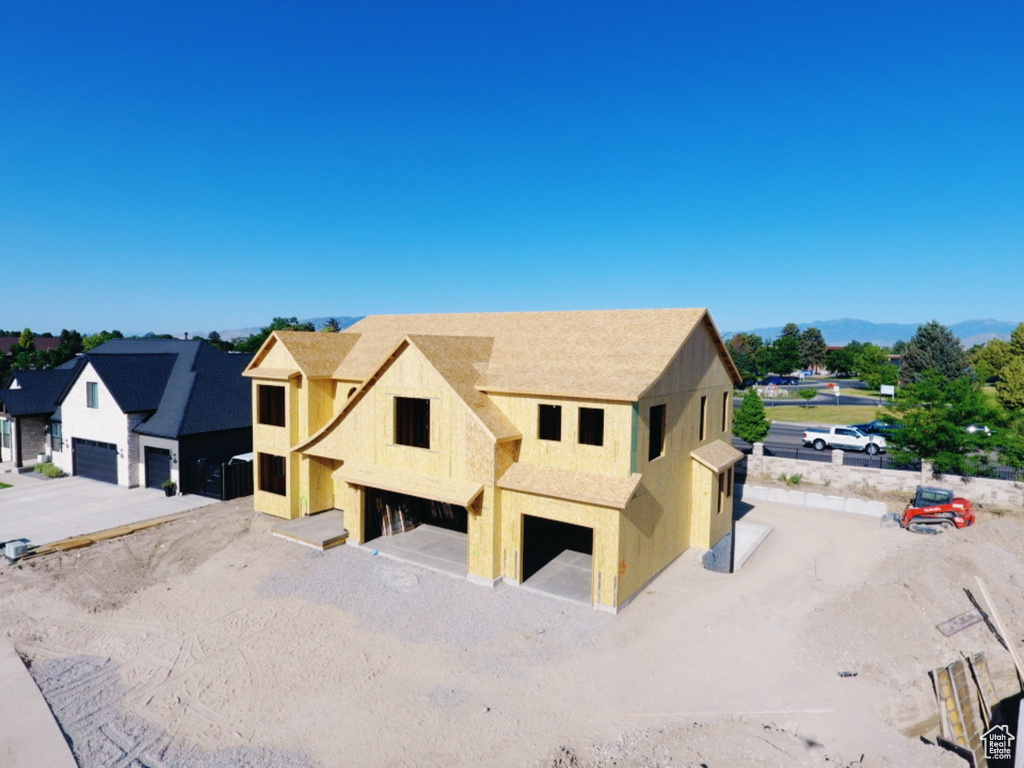 View of front of property with stucco siding, an attached garage, and driveway