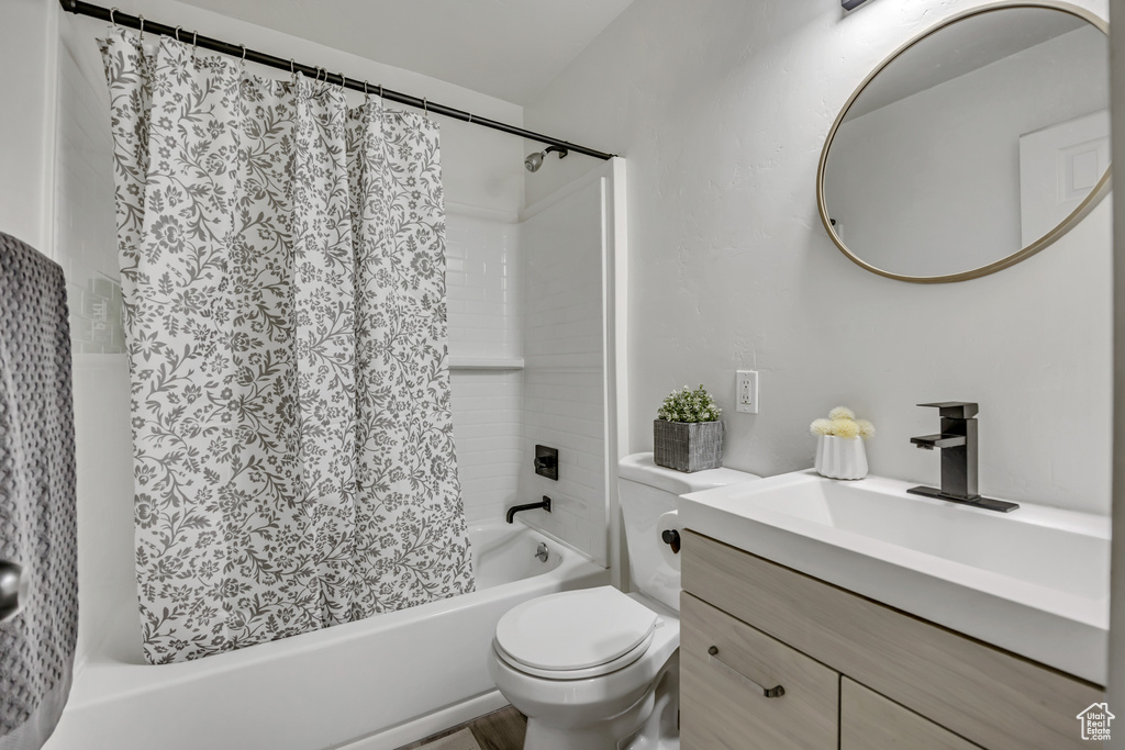 Full bathroom with shower / bath combo with shower curtain and vanity