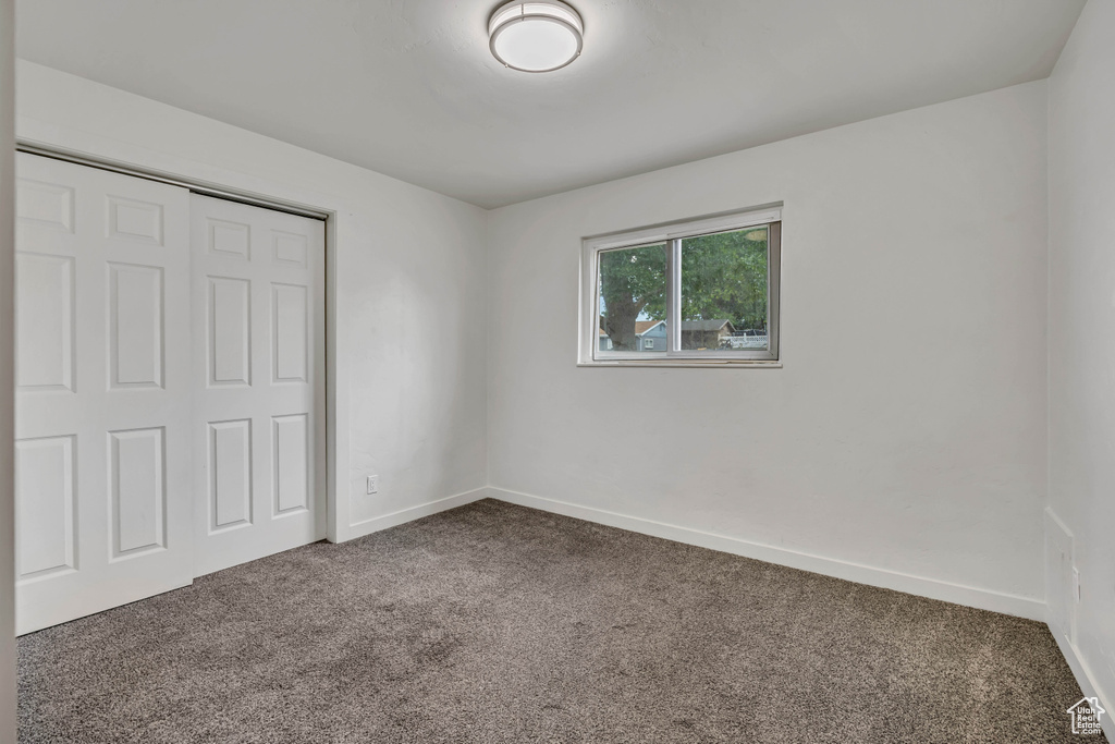 Unfurnished bedroom featuring carpet floors and a closet