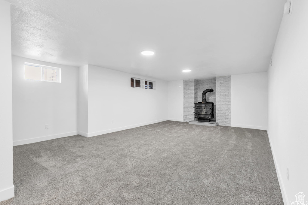 Below grade area with a wood stove, carpet floors, and recessed lighting