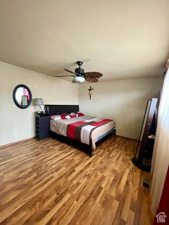 Bedroom featuring wood finished floors and a ceiling fan