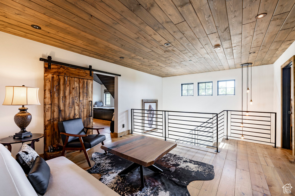 Sitting room with an upstairs landing, a barn door, wooden ceiling, wood-type flooring, and recessed lighting
