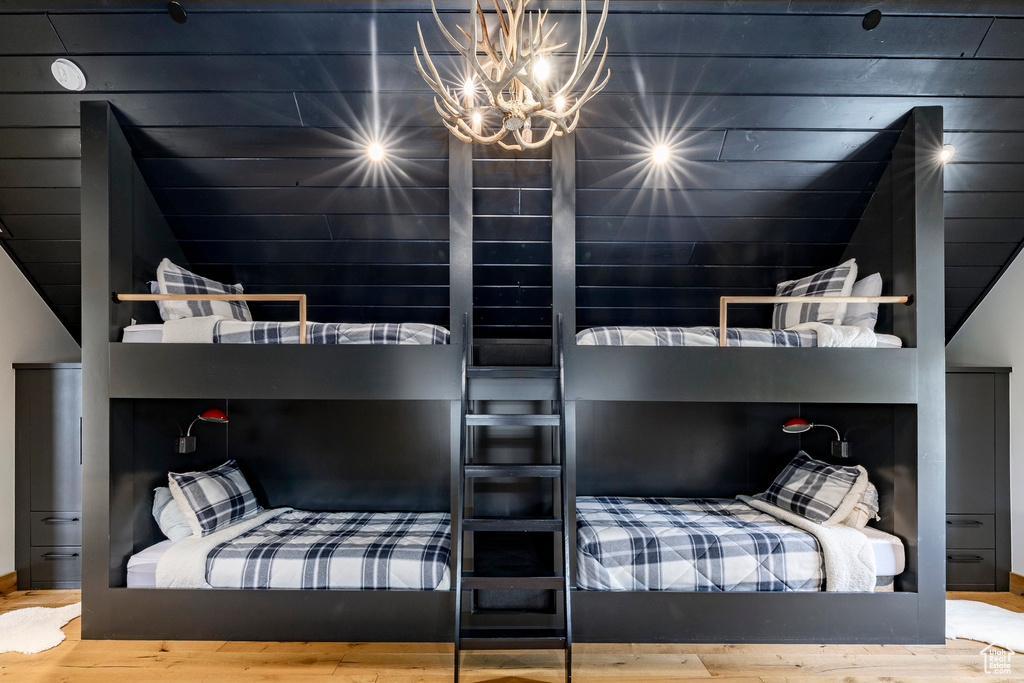 Bedroom with wood finished floors, a chandelier, and a sauna