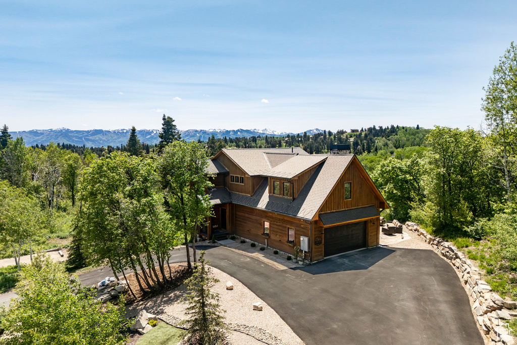 Aerial view of property and surrounding area with a mountain backdrop