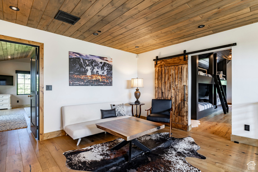 Sitting room featuring hardwood / wood-style flooring, wood ceiling, and a barn door