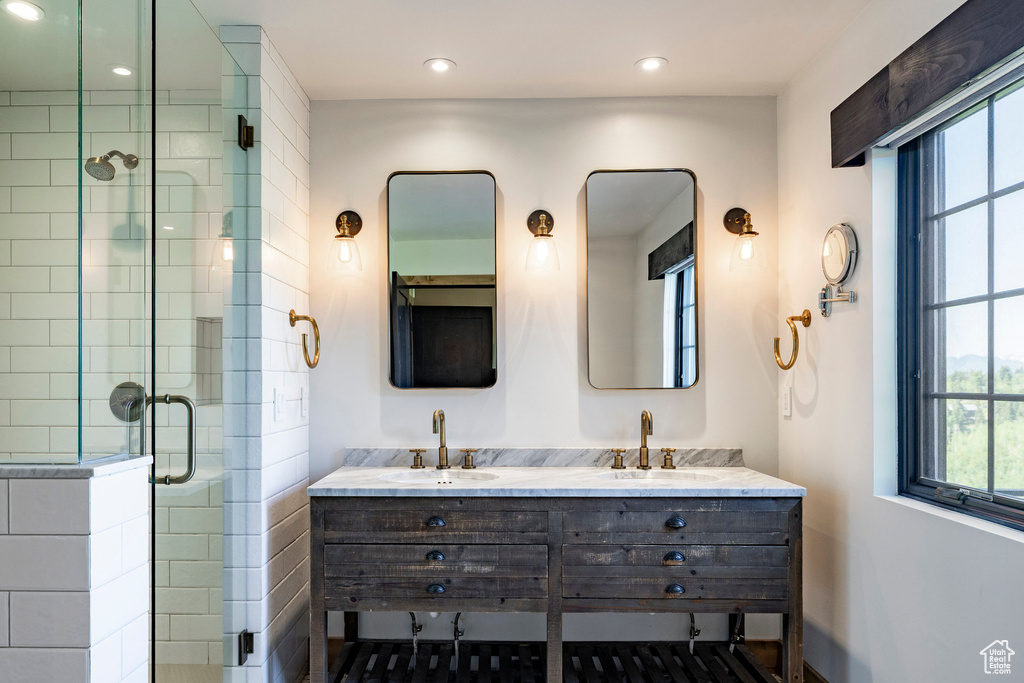 Bathroom featuring a stall shower, double vanity, and recessed lighting