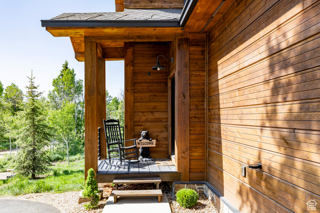 Property entrance featuring a shingled roof