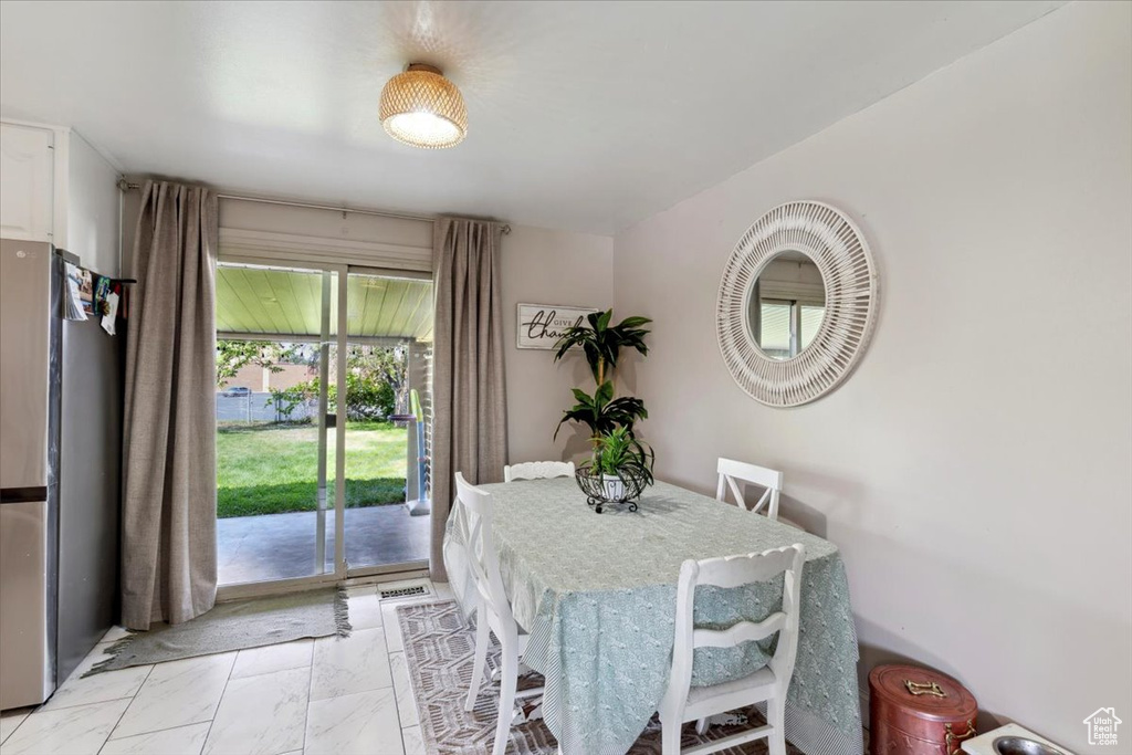 Dining space featuring light marble finish floors