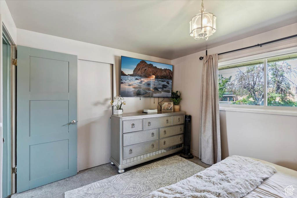 Bedroom with carpet floors and a chandelier