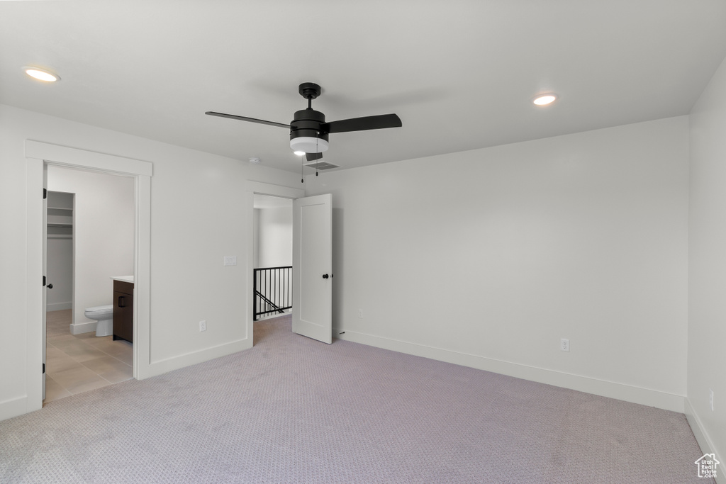 Unfurnished bedroom featuring light carpet, recessed lighting, ensuite bath, and a ceiling fan