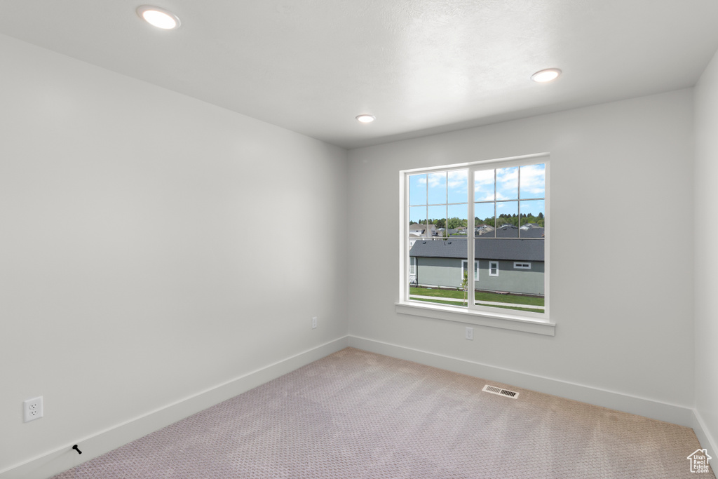 Empty room featuring light carpet and recessed lighting